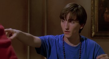 Movie still from “Can't Hardly Wait” (1998), directed by Deborah Kaplan – A young man in a blue t - shirt is holding his arm out; Close Up shot, High angle