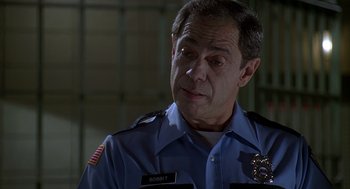 Movie still from “Can't Hardly Wait” (1998), directed by Deborah Kaplan – A police officer in uniform looking at the camera; Close Up shot, Over the shoulder angle