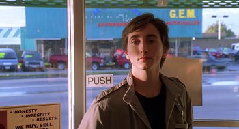 Movie still from “Can't Hardly Wait” (1998), directed by Deborah Kaplan – A man standing in front of a store window; Close Up shot, Low angle