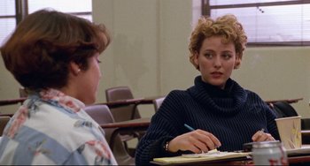 Movie still from “Candyman” (1992), directed by Bernard Rose – A woman sitting at a table writing on a piece of paper; Medium shot, Over the shoulder angle