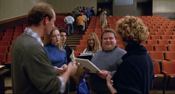 Movie still from “Candyman” (1992), directed by Bernard Rose – A group of people standing in front of a crowd; Medium shot, Over the shoulder angle