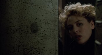 Movie still from “Candyman” (1992), directed by Bernard Rose – A woman with curly hair looking into a mirror; Close Up shot, Over the shoulder angle