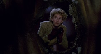 Movie still from “Candyman” (1992), directed by Bernard Rose – A woman looking into a mirror while holding a cell phone to her ear; Medium shot, Low angle