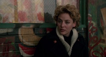 Movie still from “Candyman” (1992), directed by Bernard Rose – A person sitting on a bench near a wall; Close Up shot, Over the shoulder angle