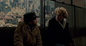 Movie still from “Candyman” (1992), directed by Bernard Rose – A man and a woman sitting next to each other on a bus; Medium shot, Over the shoulder angle