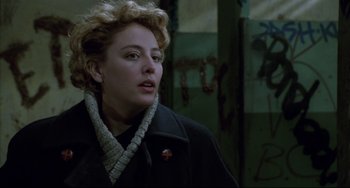 Movie still from “Candyman” (1992), directed by Bernard Rose – A woman in a black coat and a red pin; Close Up shot, Over the shoulder angle