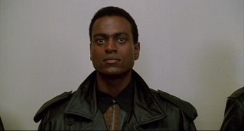 Movie still from “Candyman” (1992), directed by Bernard Rose – A man wearing a black leather jacket and a black shirt; Close Up shot, Low angle