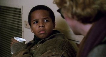 Movie still from “Candyman” (1992), directed by Bernard Rose – A young boy looking at another person in a room; Close Up shot, Over the shoulder angle