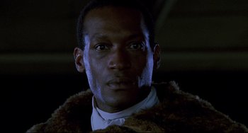 Movie still from “Candyman” (1992), directed by Bernard Rose – A person wearing a suit and tie; Close Up shot, Low angle