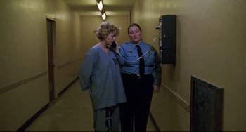 Movie still from “Candyman” (1992), directed by Bernard Rose – Two women in a hallway talking on a phone; Medium shot, High angle