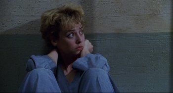 Movie still from “Candyman” (1992), directed by Bernard Rose – A woman sitting on the ground with her head resting on her hand; Close Up shot, High angle