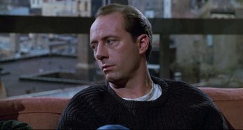 Movie still from “Candyman” (1992), directed by Bernard Rose – A person sitting on a couch; Close Up shot, Over the shoulder angle