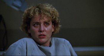 Movie still from “Candyman” (1992), directed by Bernard Rose – A person sitting down crying; Close Up shot, Low angle