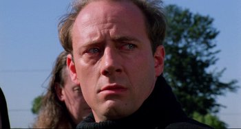 Movie still from “Candyman” (1992), directed by Bernard Rose – A person wearing a black jacket; Close Up shot, Low angle