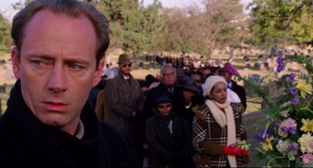 Movie still from “Candyman” (1992), directed by Bernard Rose – A crowd of people standing in a field; Close Up shot, Over the shoulder angle