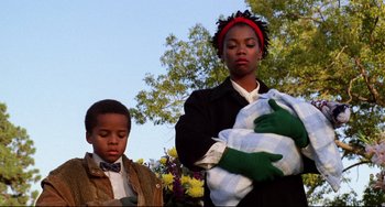 Movie still from “Candyman” (1992), directed by Bernard Rose – A woman and a boy standing next to each other; Medium shot, Low angle