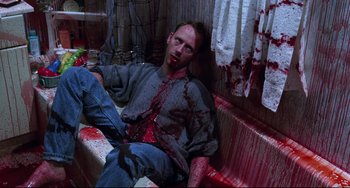 Movie still from “Candyman” (1992), directed by Bernard Rose – A man with blood all over his face and body; Medium shot, High angle