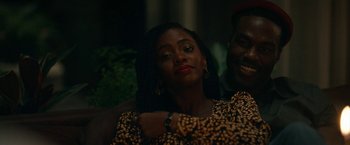 Movie still from “Candyman” (2021), directed by Nia DaCosta – A woman in a leopard print shirt is hugging a man in a leopard print shirt; Close Up shot, Over the shoulder angle