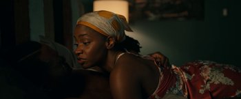 Movie still from “Candyman” (2021), directed by Nia DaCosta – A woman with a head scarf on her head; Close Up shot, Over the shoulder angle