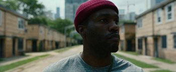 Movie still from “Candyman” (2021), directed by Nia DaCosta – A person wearing a hat; Close Up shot, Over the shoulder angle