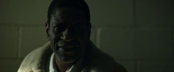 Movie still from “Candyman” (2021), directed by Nia DaCosta – A man's face in a dark room; Close Up shot, Over the shoulder angle