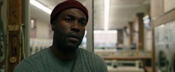 Movie still from “Candyman” (2021), directed by Nia DaCosta – A person wearing a hat; Close Up shot, Low angle