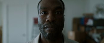 Movie still from “Candyman” (2021), directed by Nia DaCosta – A man's face in a dark room; Extreme Close Up shot, Low angle