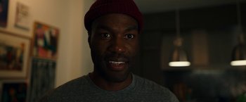 Movie still from “Candyman” (2021), directed by Nia DaCosta – A person wearing a hat; Close Up shot, Over the shoulder angle