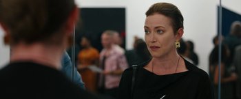 Movie still from “Candyman” (2021), directed by Nia DaCosta – A woman standing in front of a group of people; Close Up shot, Over the shoulder angle