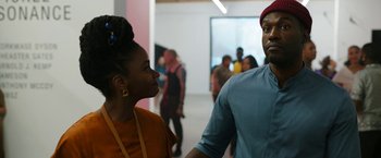 Movie still from “Candyman” (2021), directed by Nia DaCosta – A man and a woman standing next to each other in a room; Medium shot, Over the shoulder angle