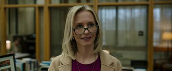 Movie still from “Candyman” (2021), directed by Nia DaCosta – A woman wearing glasses and a brown jacket; Close Up shot, Over the shoulder angle