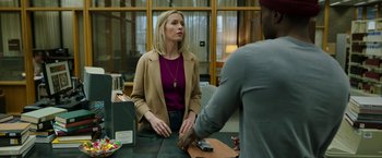 Movie still from “Candyman” (2021), directed by Nia DaCosta – A woman is sitting at a table talking to a man; Medium shot, Over the shoulder angle