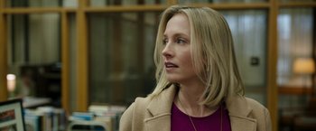 Movie still from “Candyman” (2021), directed by Nia DaCosta – A woman with blonde hair wearing a pink shirt and jacket; Close Up shot, Over the shoulder angle