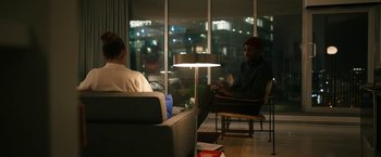 Movie still from “Candyman” (2021), directed by Nia DaCosta – Two men are sitting in front of a window; Wide shot, Over the shoulder angle