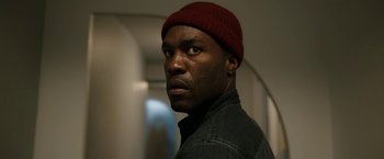 Movie still from “Candyman” (2021), directed by Nia DaCosta – A person wearing a hat; Close Up shot, Low angle