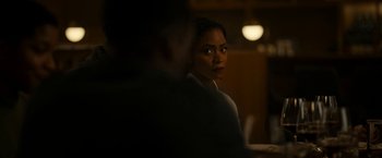 Movie still from “Candyman” (2021), directed by Nia DaCosta – A woman standing next to a man in a dark room; Close Up shot, Over the shoulder angle
