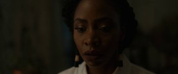 Movie still from “Candyman” (2021), directed by Nia DaCosta – A person wearing a white shirt; Close Up shot, Over the shoulder angle