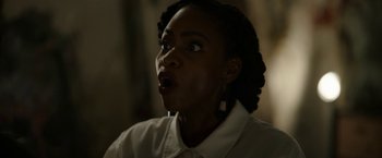Movie still from “Candyman” (2021), directed by Nia DaCosta – A woman with her mouth wide open looking surprised; Close Up shot, Low angle
