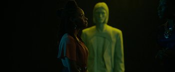 Movie still from “Candyman” (2021), directed by Nia DaCosta – A woman standing in front of a man in a hooded jacket; Medium shot, Over the shoulder angle