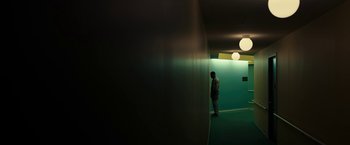 Movie still from “Candyman” (2021), directed by Nia DaCosta – A man standing in a room with a green wall behind him; Extreme Wide shot, Low angle