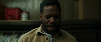 Movie still from “Candyman” (2021), directed by Nia DaCosta – A black man with a beard is looking down at his face; Close Up shot, High angle