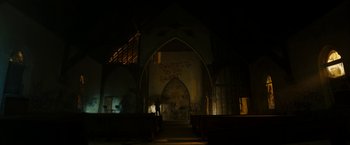 Movie still from “Candyman” (2021), directed by Nia DaCosta – A person standing in front of an old church; Extreme Wide shot, Low angle