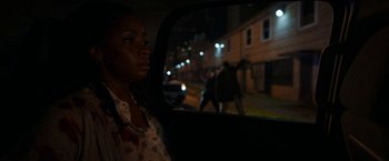 Movie still from “Candyman” (2021), directed by Nia DaCosta – A woman sitting in the back seat of a car at night; Close Up shot, Over the shoulder angle
