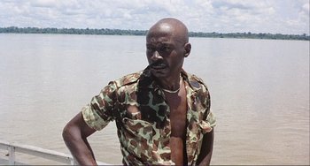 Movie still from “Cannibal Holocaust” (1980), directed by Ruggero Deodato – A man standing in a body of water; Medium shot, Low angle
