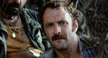 Movie still from “Cannibal Holocaust” (1980), directed by Ruggero Deodato – A person with a beard and mustache; Close Up shot, Low angle