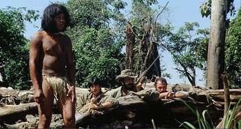 Movie still from “Cannibal Holocaust” (1980), directed by Ruggero Deodato – A group of men sitting next to each other on top of a tree; Wide shot, Low angle