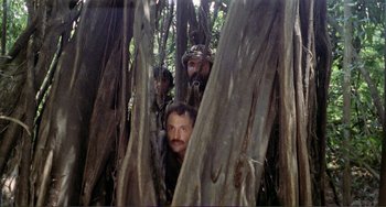 Movie still from “Cannibal Holocaust” (1980), directed by Ruggero Deodato – A group of men hiding in the trees; Wide shot, Low angle
