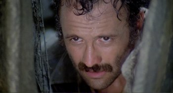 Movie still from “Cannibal Holocaust” (1980), directed by Ruggero Deodato – A person with a beard; Close Up shot, Low angle