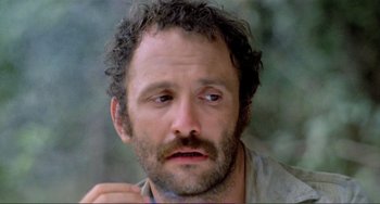 Movie still from “Cannibal Holocaust” (1980), directed by Ruggero Deodato – A person with curly hair and a beard; Close Up shot, Low angle