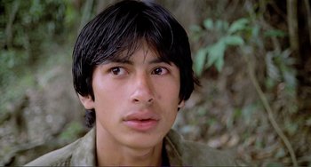 Movie still from “Cannibal Holocaust” (1980), directed by Ruggero Deodato – A man with long black hair is looking at the camera; Close Up shot, Low angle